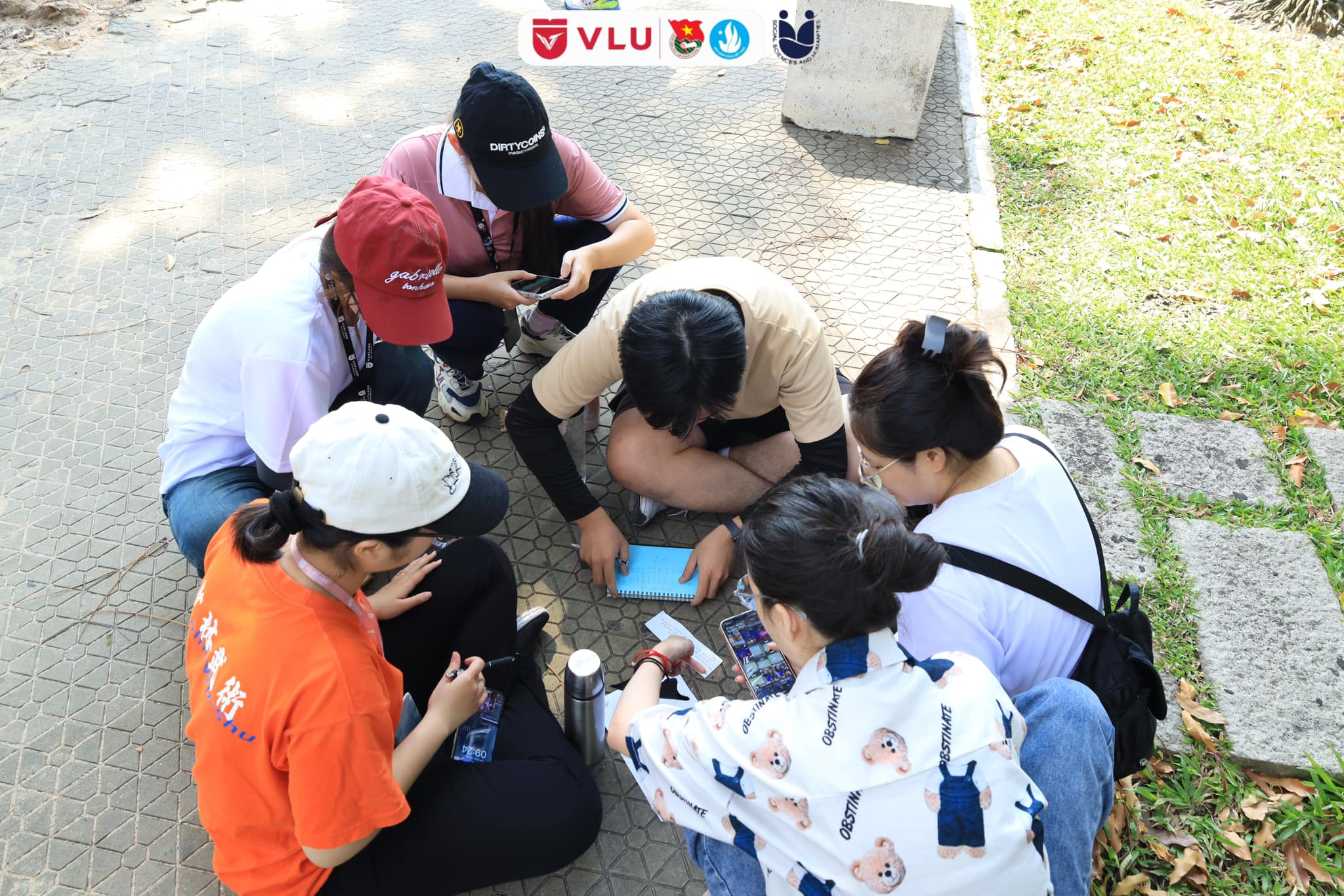 A group of people sitting on the ground

Description automatically generated