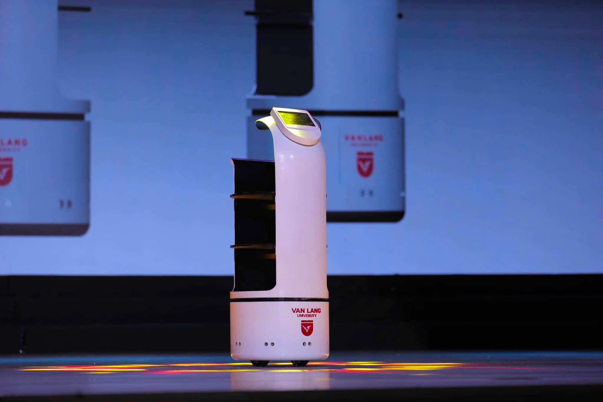 A white machine on a stage
Description automatically generated