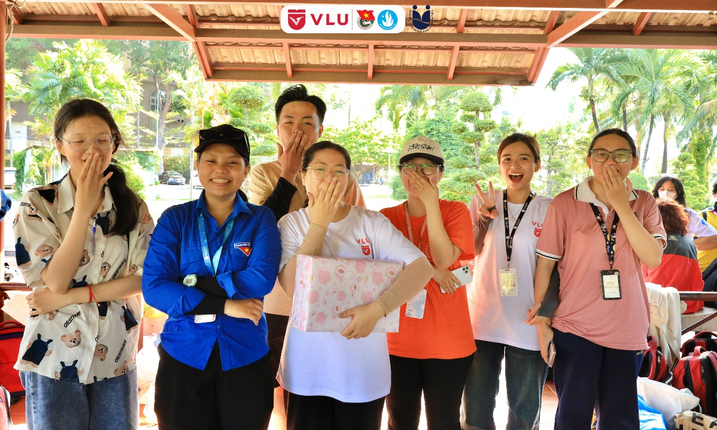 A group of people standing under a canopy

Description automatically generated