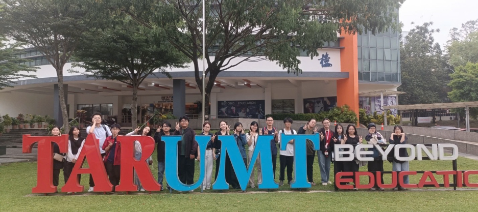 A group of people standing in front of a sign

Description automatically generated